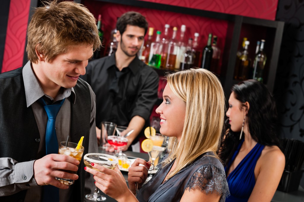 Cocktail bar young happy couple friends enjoy drinks